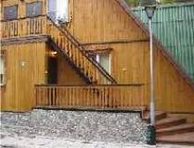 Вид крыльца дома с лестницей на второй этаж.